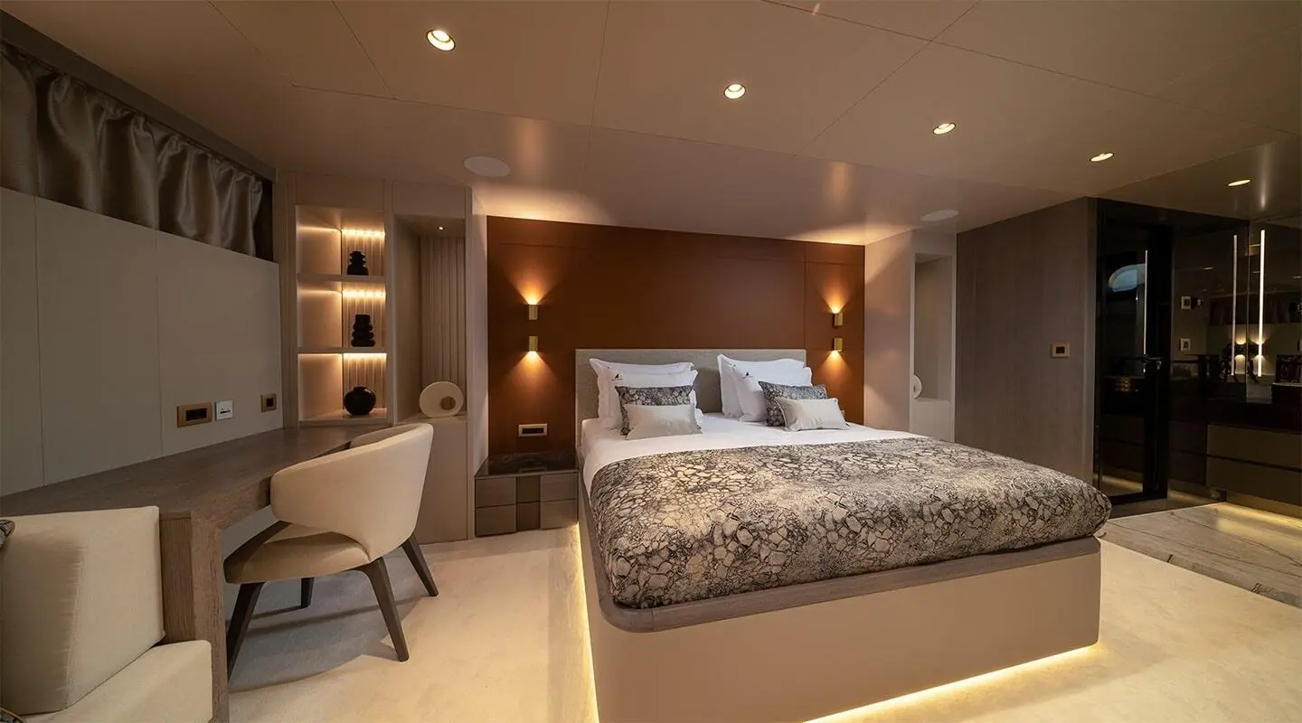 Nocturno luxury yacht cabin interior with bed, bedside lamps, and seating