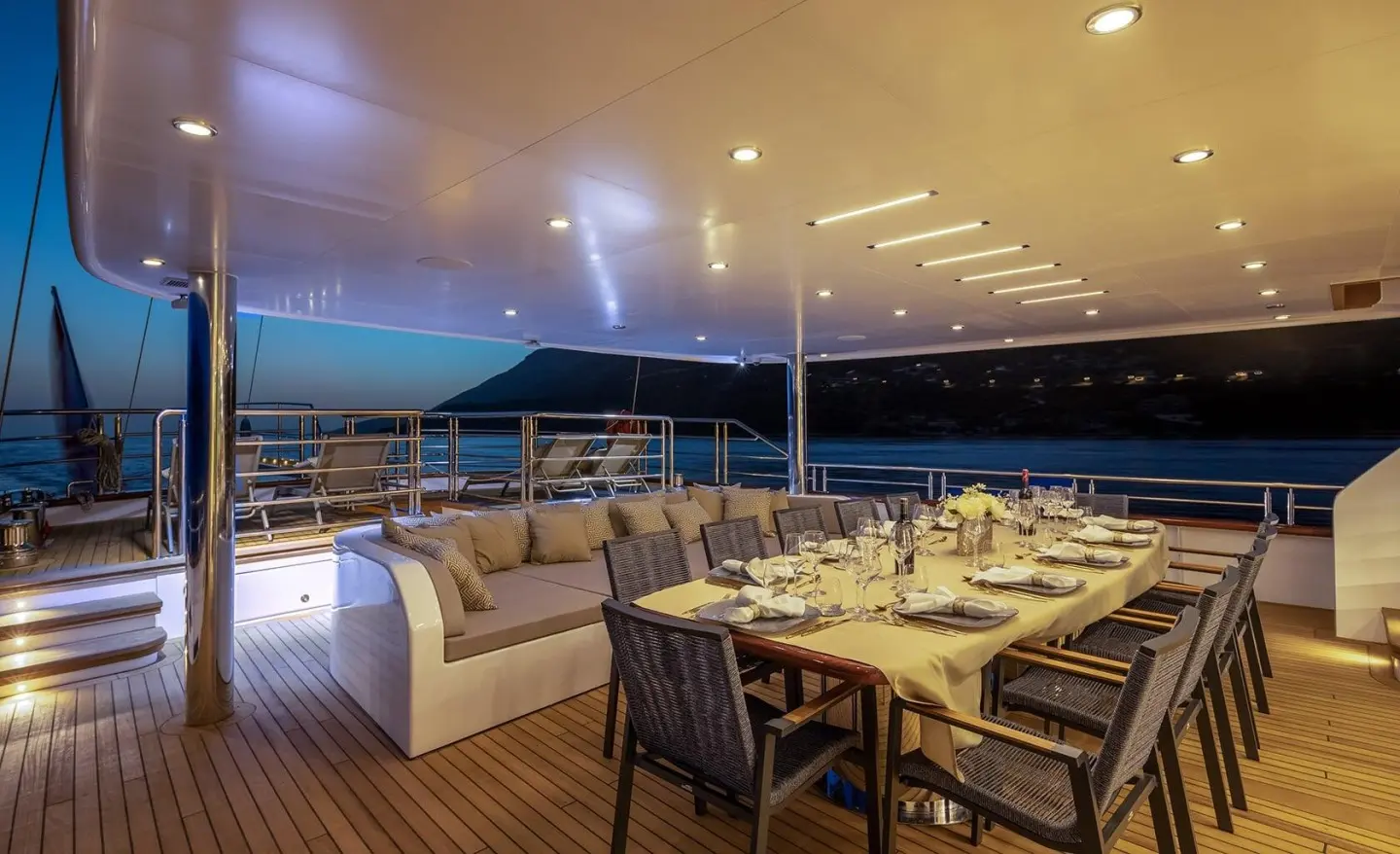 Evening deck on Love Story yacht with dining setup and warm lights