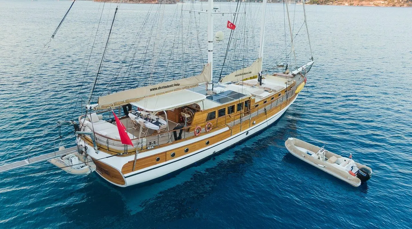 Derin Deniz yacht anchored with a wooden deck, ocean calm water, and distant horizon