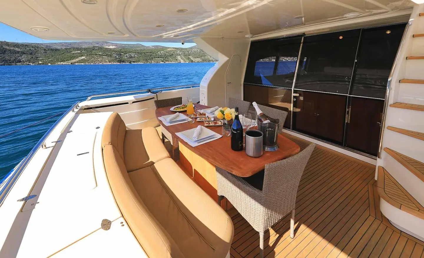 Aft deck of Quo Vadis I yacht with seating, table, and sun loungers aboard