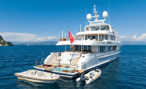 Serenity yacht anchored near a smaller tender on clear blue water