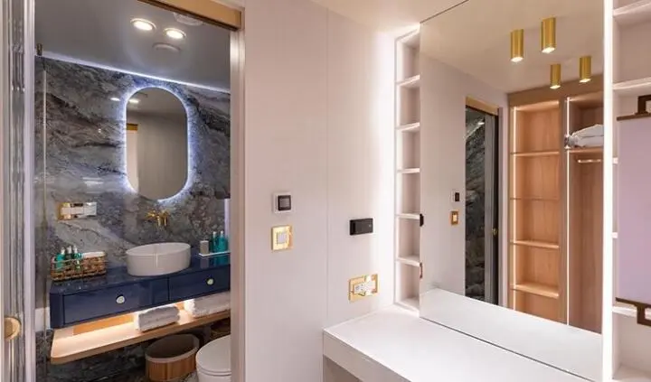 Scorpios cabin ensuite bed on yacht, white fixtures and mirror