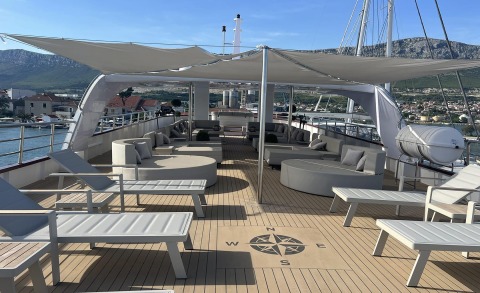 Melody yacht wide deck with central seating and shaded lounge area