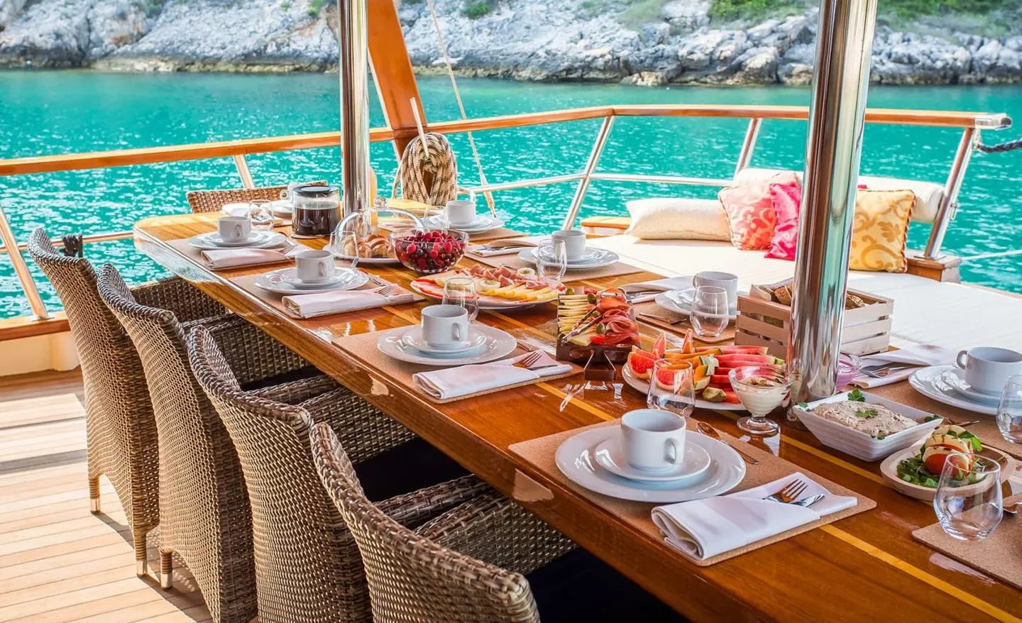 Dining area on the aft deck of gulet Altair with table settings and sea view
