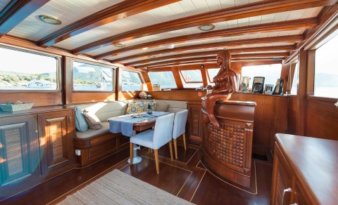 Wooden interior with dining table and seating area, carved mermaid figure on the bar