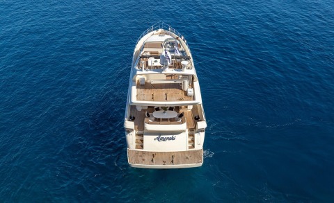 Amoraki yacht seen from above with teak decks and seating areas over blue sea