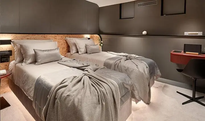 Master cabin with two twin beds pushed together, beige bedding, nightstands, and neutral walls