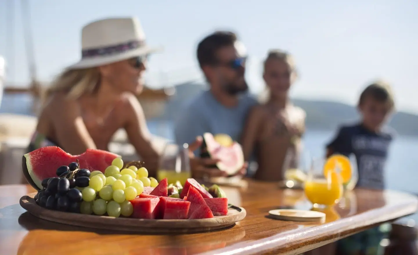 Gulet Entre Cielos with a fruit platter and guests dining on deck