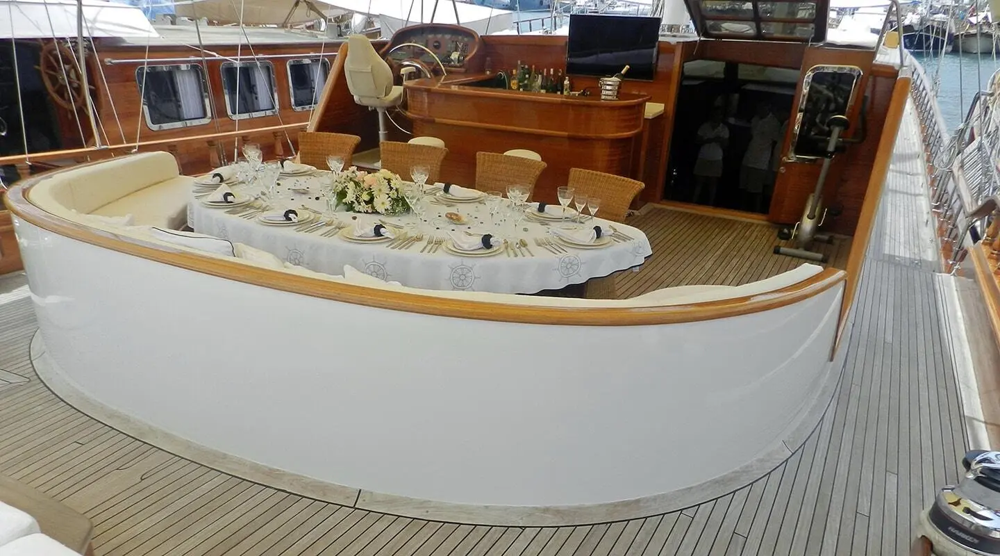 Aft deck of Kaya Guneri 4 gulet with wooden seating and lifebuoy on rail
