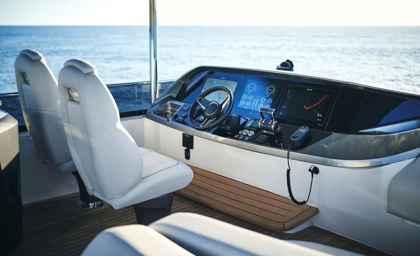 Cockpit on Elizabeth yacht at sunset with steering wheel and navigation screens