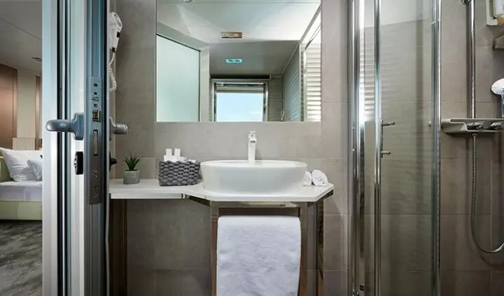 Small yacht cabin bathroom with sink, mirror, and towels visible