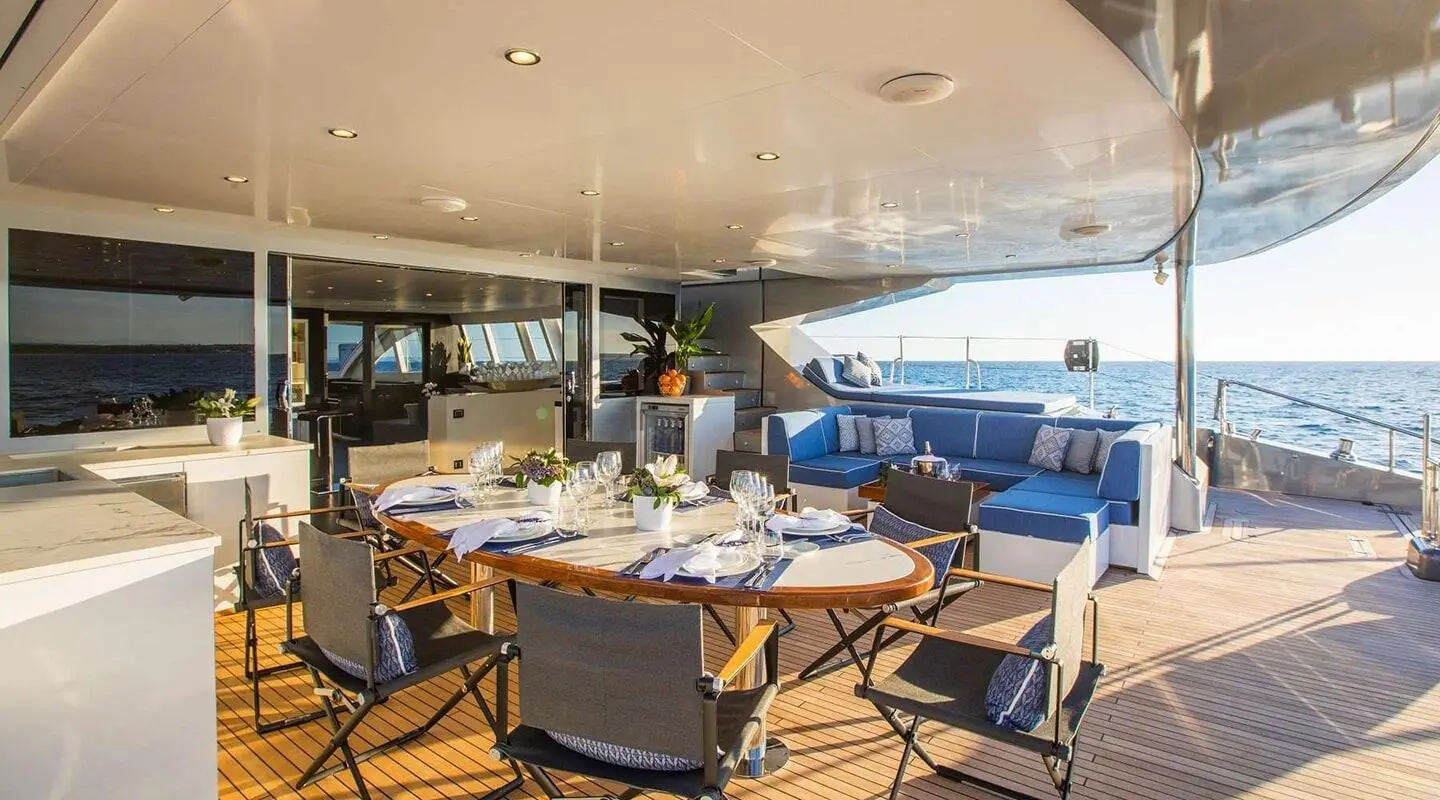 Cartouche yacht aft deck dining area with table set and seating