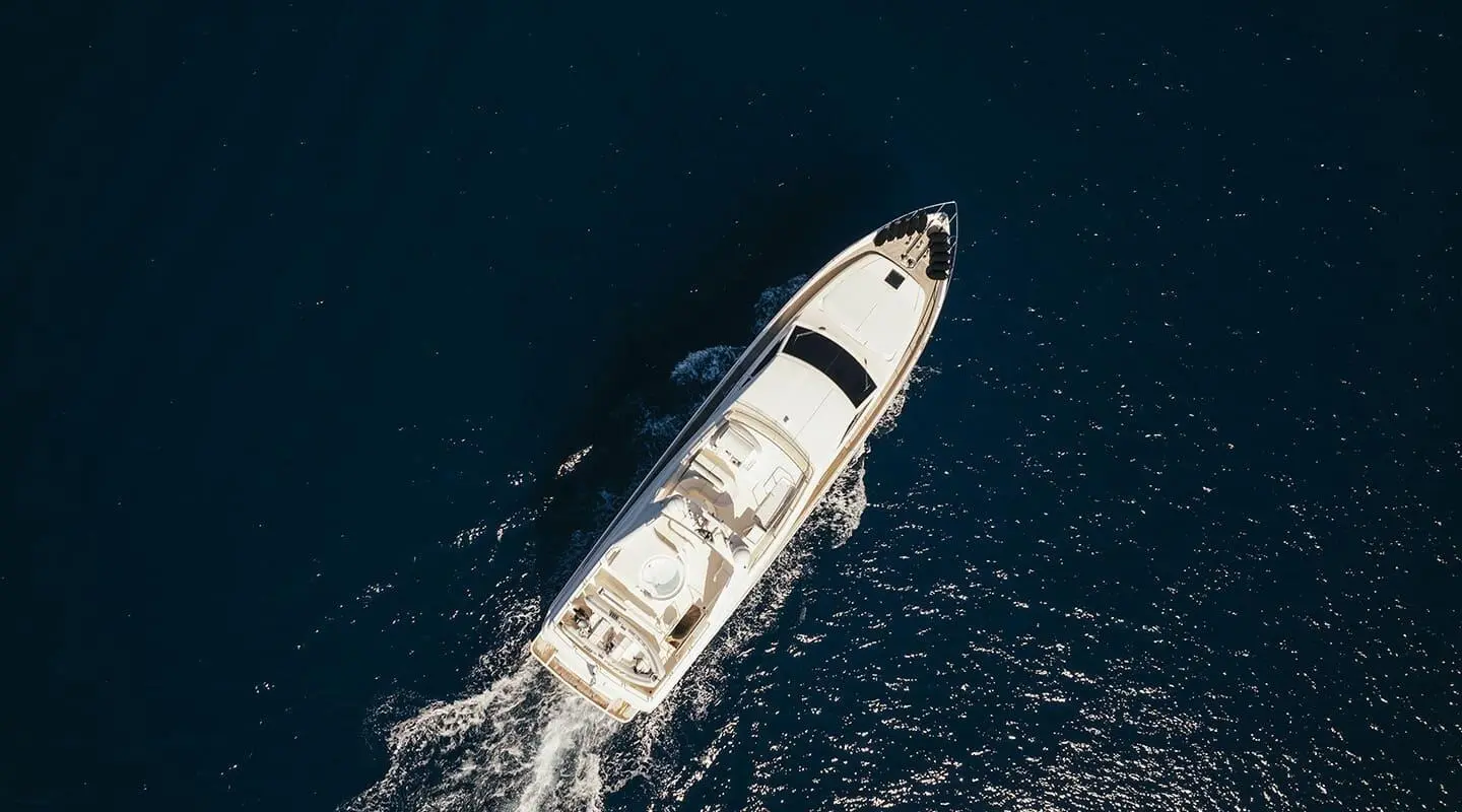A sleek white luxury yacht named Lidia cruises calm blue waters, bow cutting waves