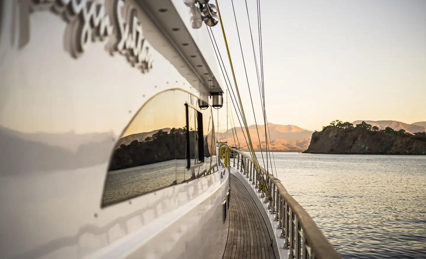 Side deck of Belgin Sultan gulet with ropes and railing along water