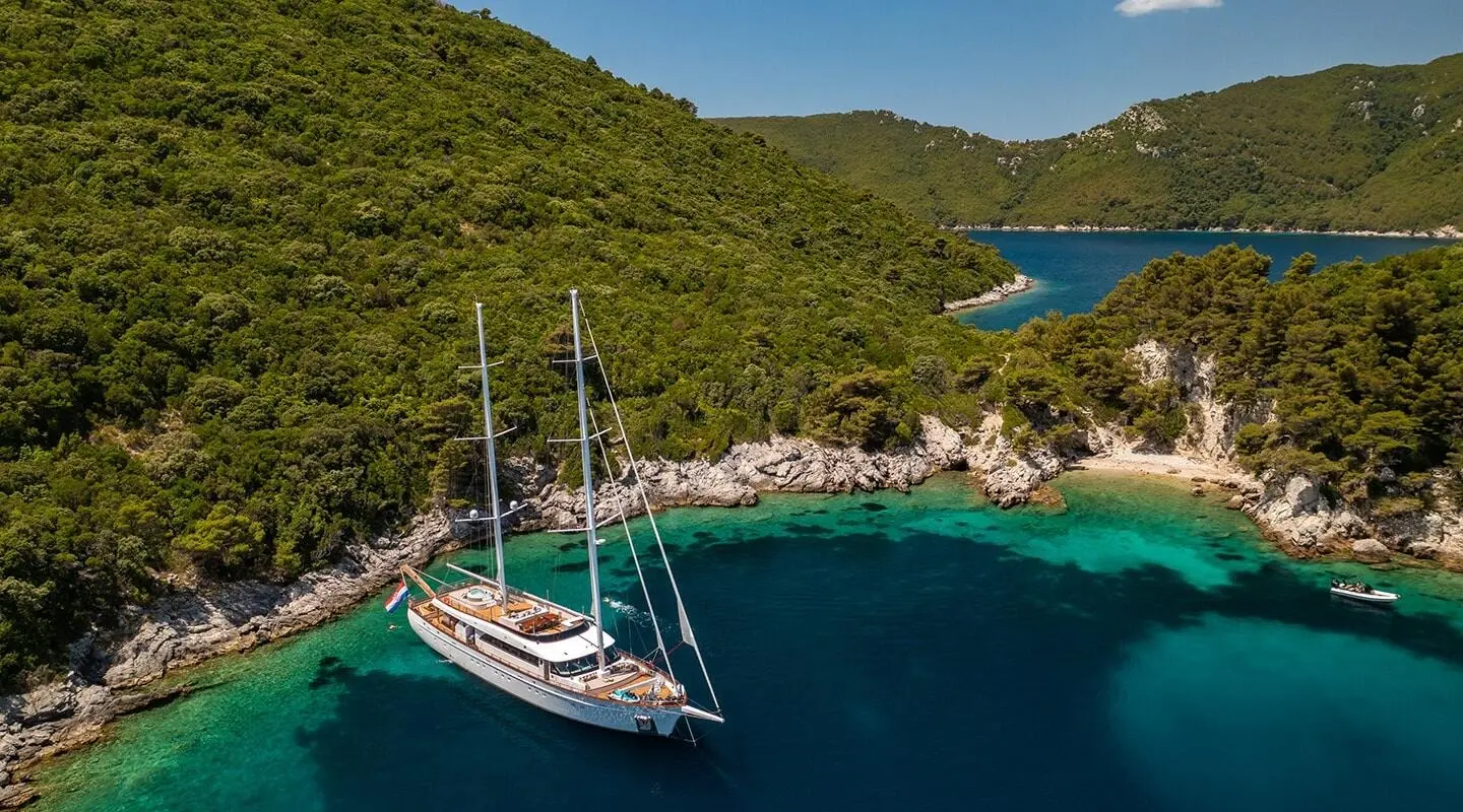 Love Story luxury gulet at sunset anchored near a rocky coastline