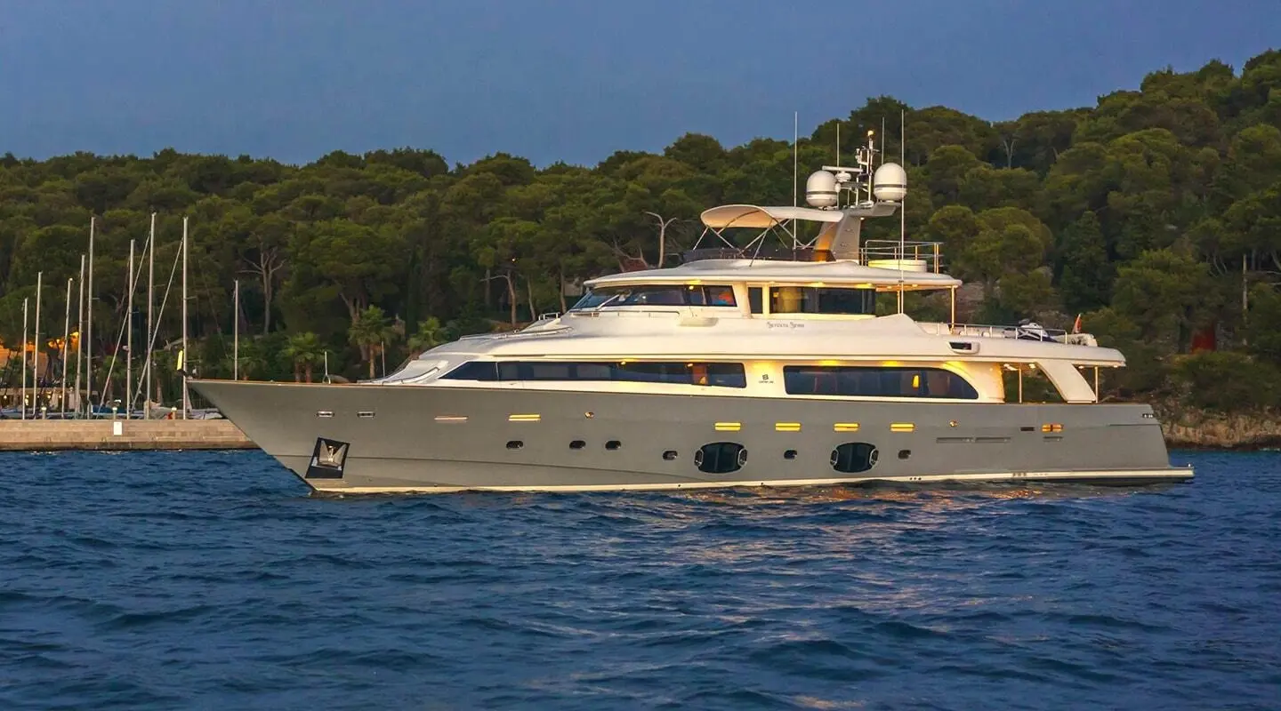 Seventh Sense luxury motor yacht anchored on calm blue water near shore