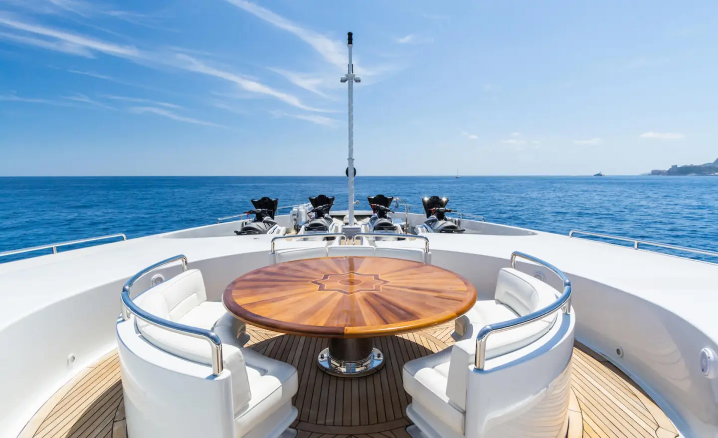 APOGEE yacht deck dining area with wooden round table and seating on bow