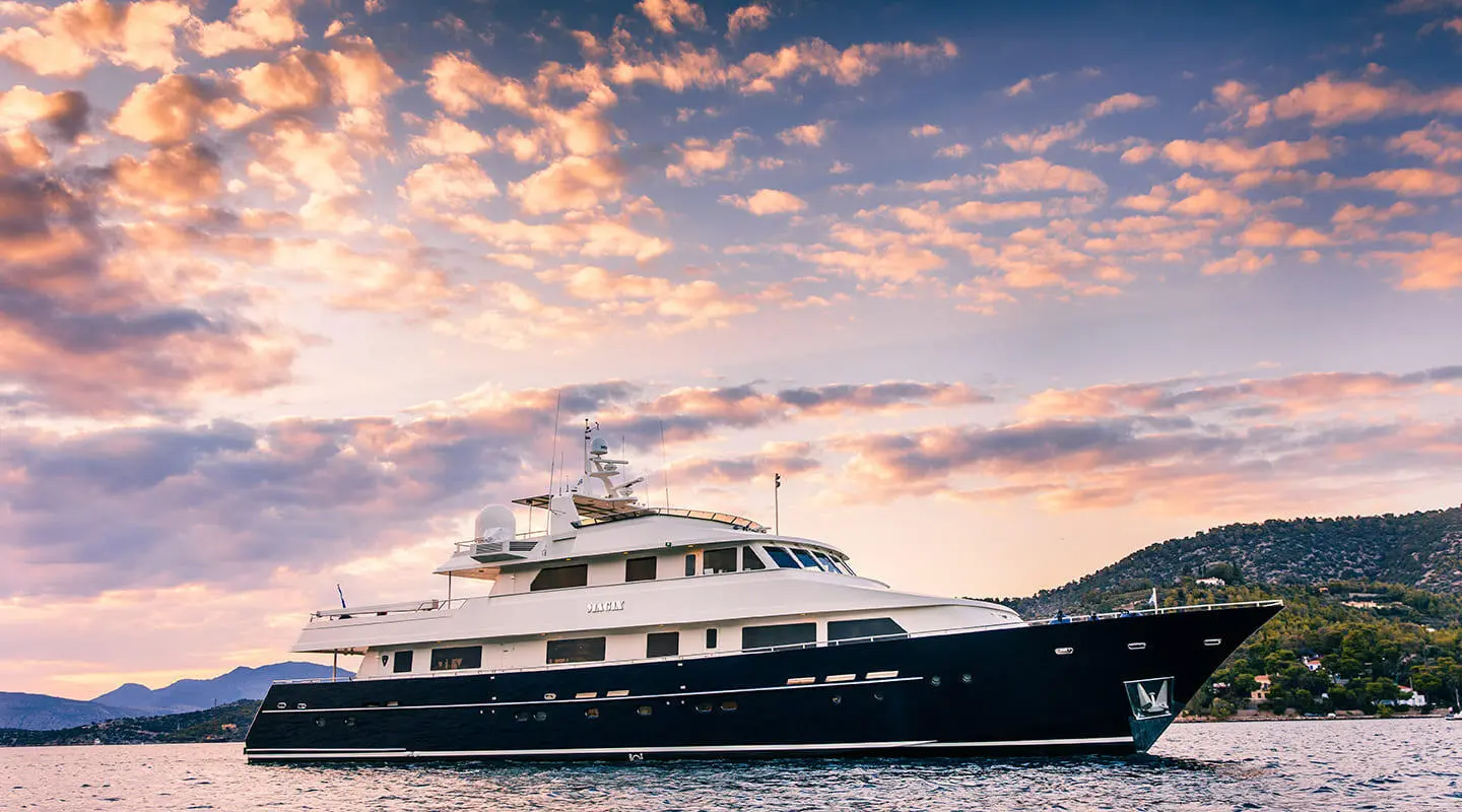 Luxurious motor yacht Magix anchored on calm water, multiple decks visible