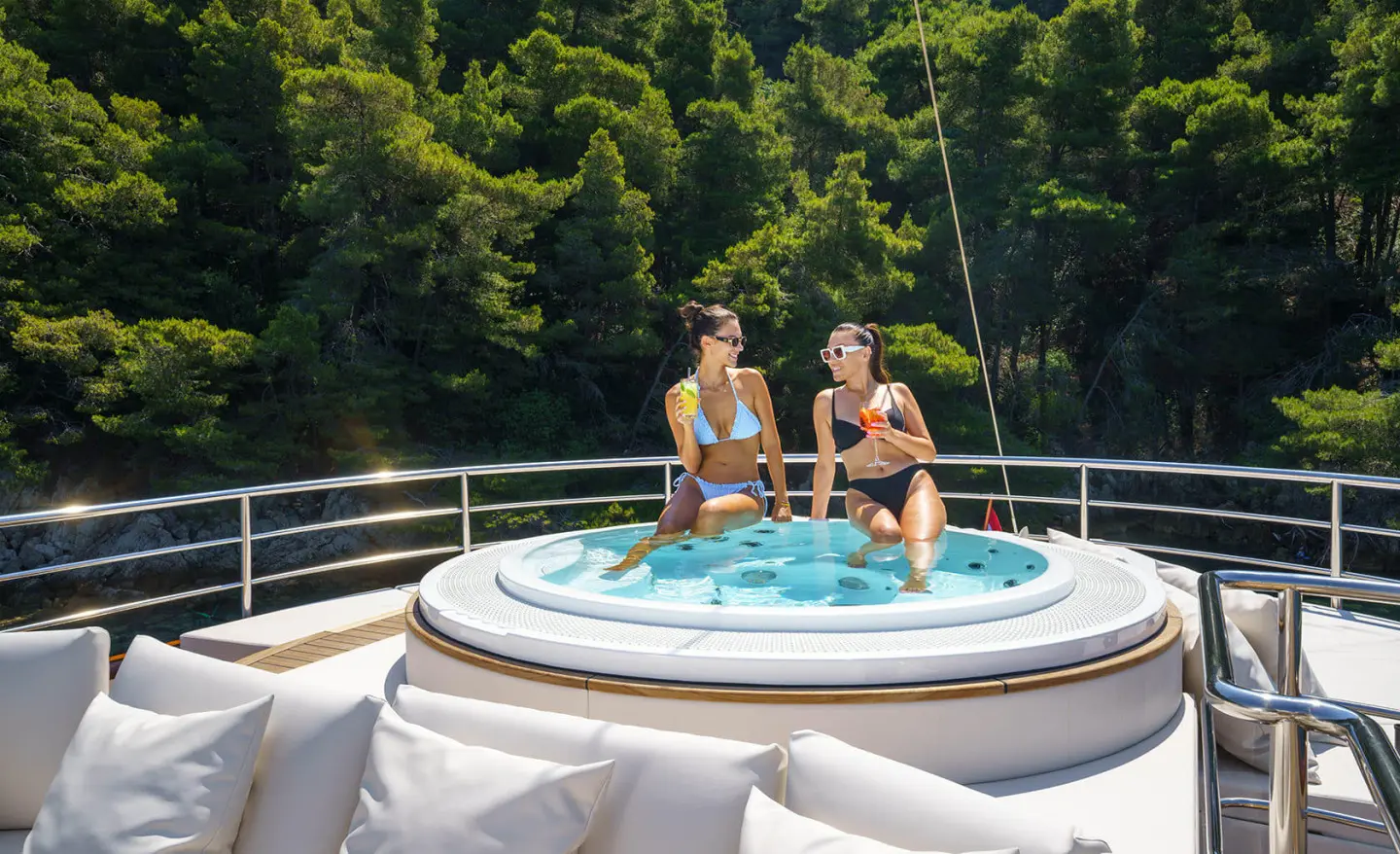 Maia yacht hot tub on deck with two people relaxing under night sky