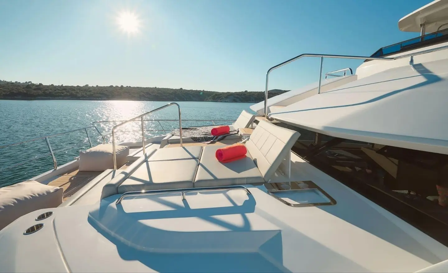 Bow deck of By My Side yacht with white seating and railings on sunny sea