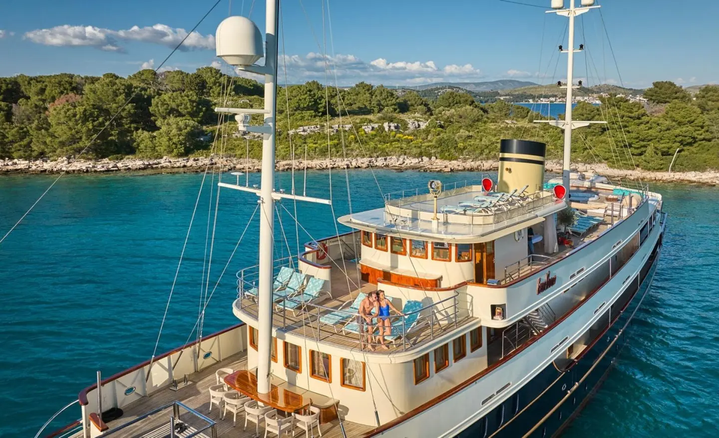 Yacht Casablanca anchored by calm blue water with a deck party setup