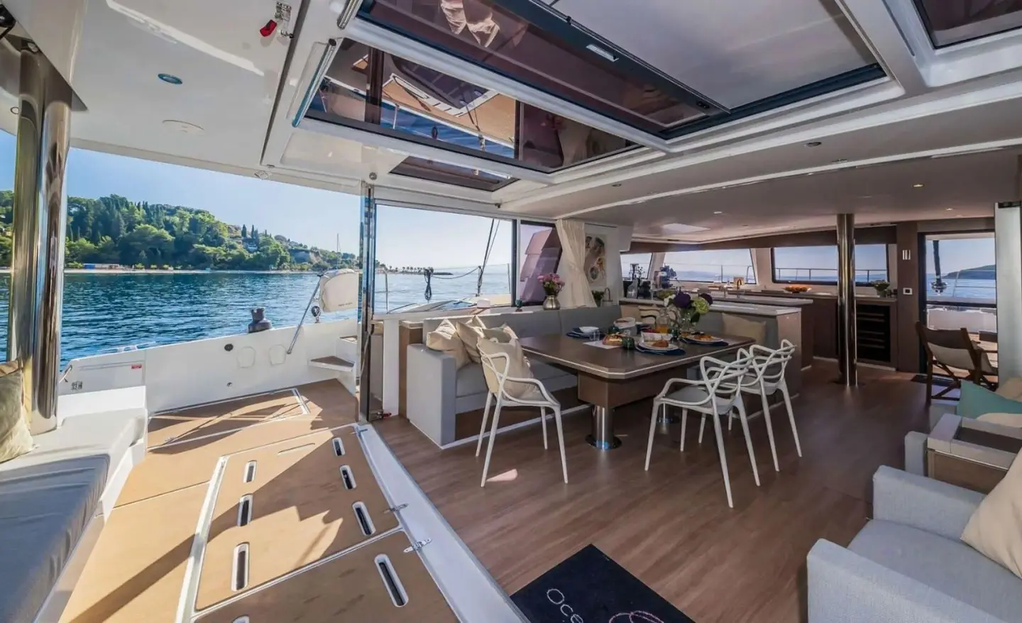Ocean Lounge dining deck on a yacht with table, chairs, and sunlit view