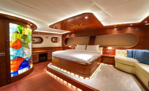Luxurious interior with a large bed and wooden paneling on a yacht cabin