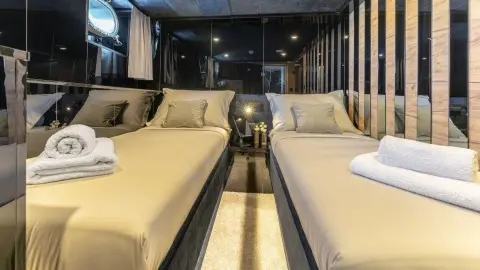 Interior of Santa Clara motor yacht with twin beds and compact seating
