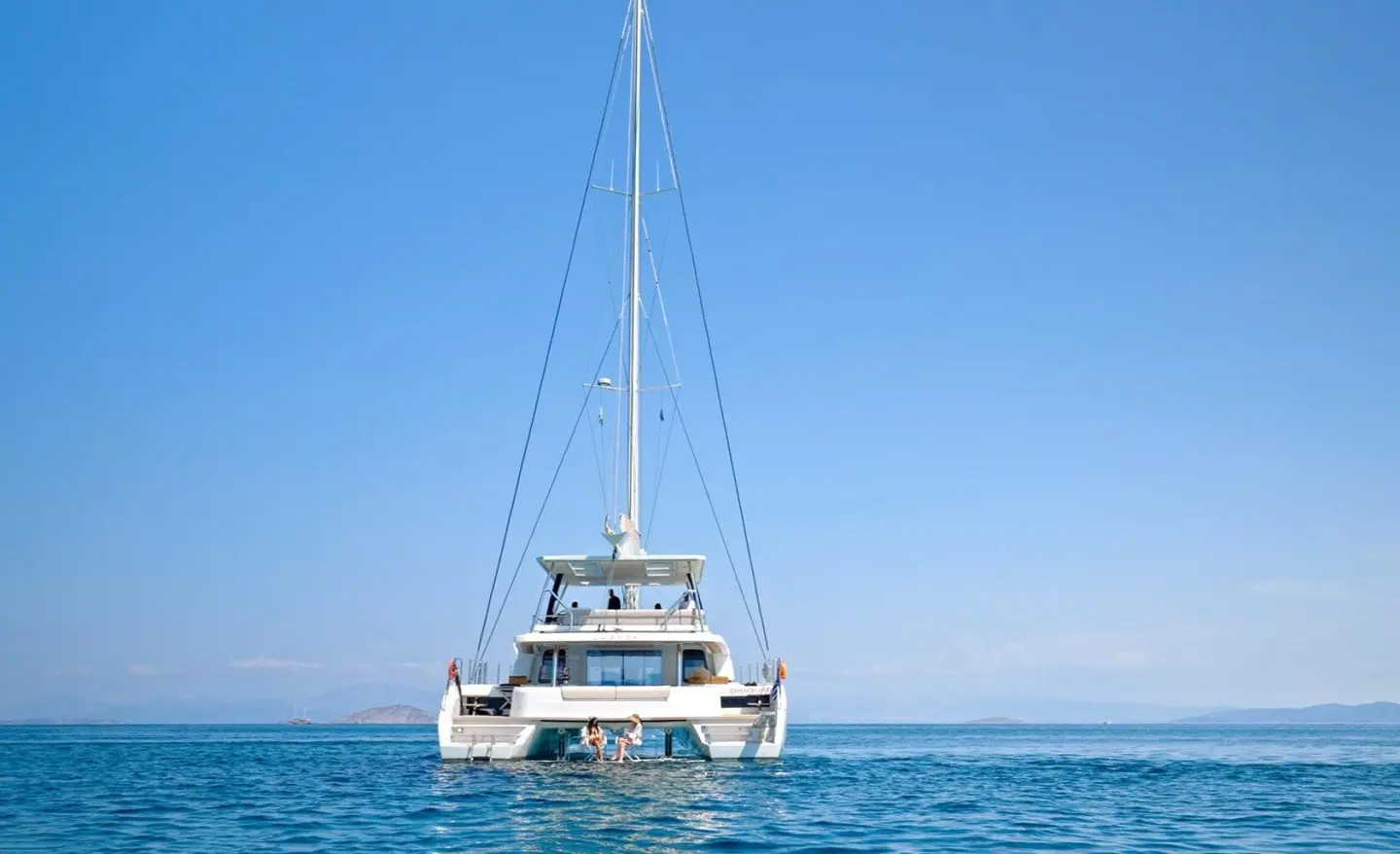 Sailing catamaran Daiquiri anchored on calm blue sea with clear sky