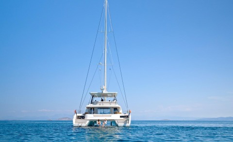 White yacht anchored in calm blue sea with clear sky