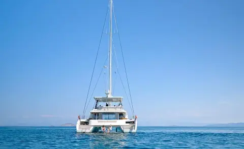 Sailing catamaran Daiquiri anchored on calm blue sea with clear sky