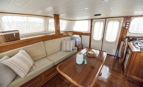 Interior with wooden seating area, coffee table, and windows with curtains
