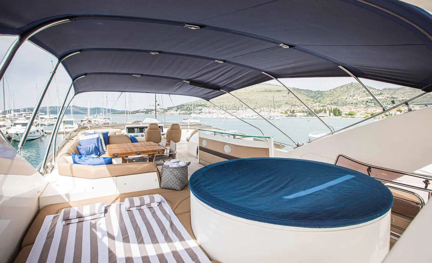 Yacht Insieme deck at sunset with blue cushion seating and striped rug