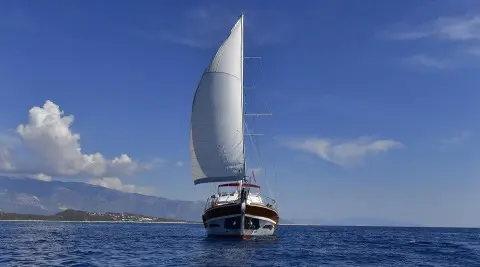 Sailing yacht Blu Dream with a large white sail, blue sea, clear sky