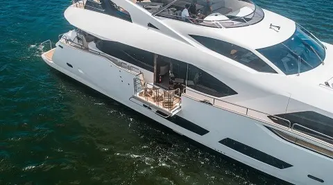 Quantum yacht anchored with passengers on deck near calm water, luxury vessel