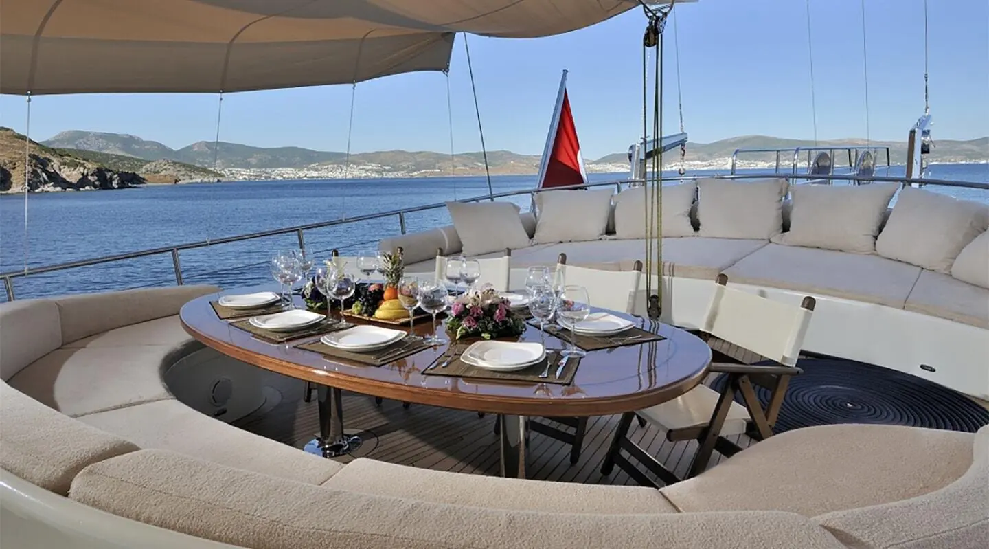 Aft deck of Dolce Mare gulet with table settings under a shade sail