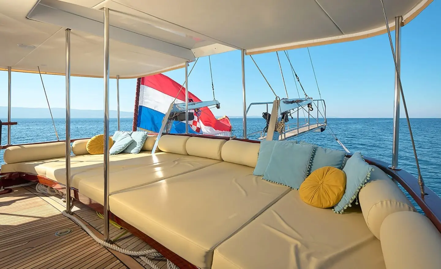 Linda yacht sun deck lounge with cream cushions and decorative pillows overlooking the sea