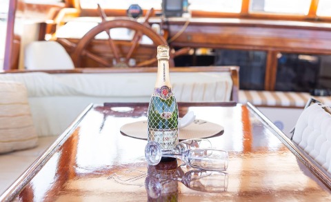 Gardelin luxury yacht deck with champagne bottle on polished wooden table