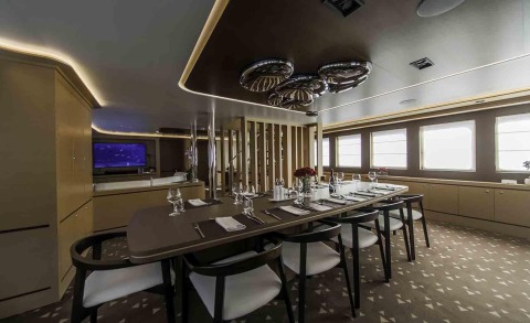 Dining table set with cutlery and glasses in a luxury yacht interior