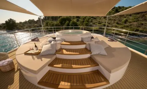 Aerial view of Bellezza yacht deck with steps, seating, and wooden flooring