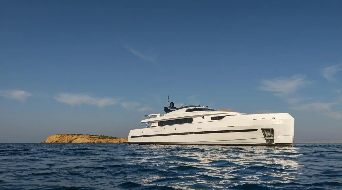 Side view of Yacht Project Steel cruising on calm blue water under clear sky