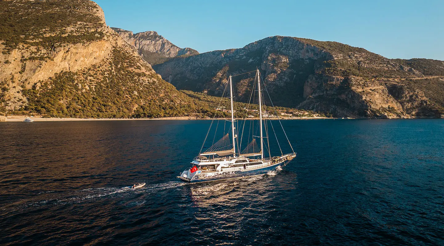 Esma Sultan luxury gulet anchored at sunset with sails down and calm blue water