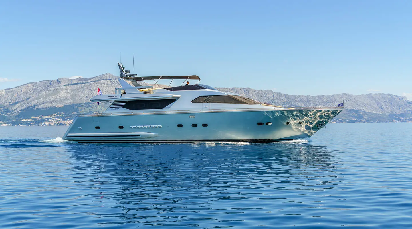 Phantom luxury motor yacht anchored on calm blue water with clear sky