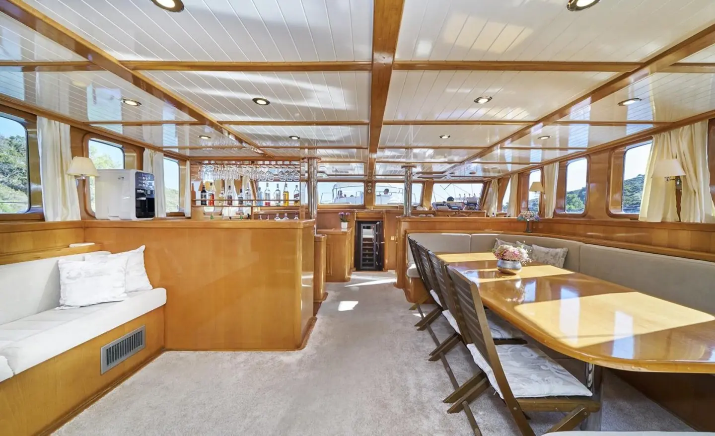 Interior of Morning Star gulet with wooden furniture and windows along the saloon