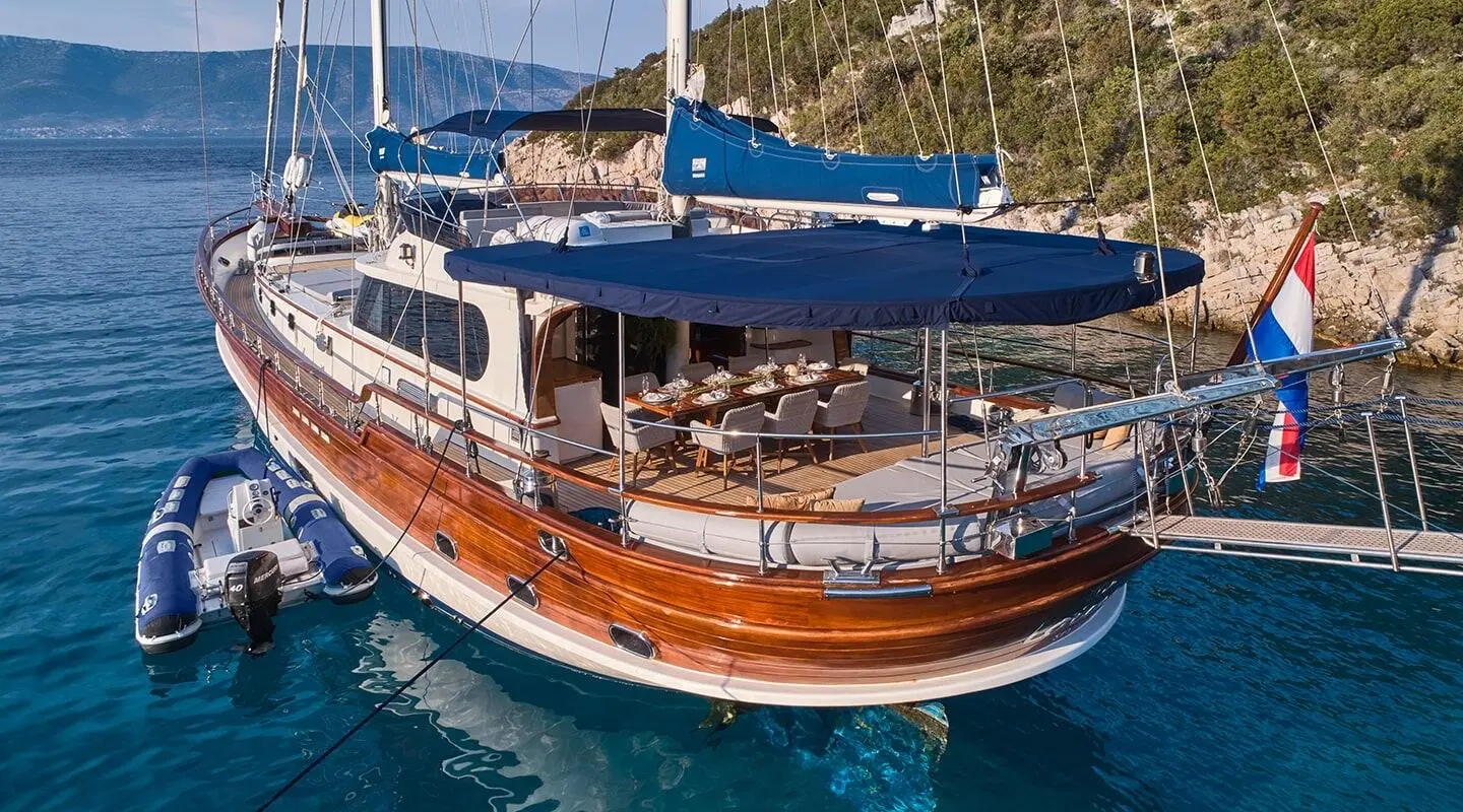 Lotus luxury gulet yacht anchored with white and blue hulls in clear blue water