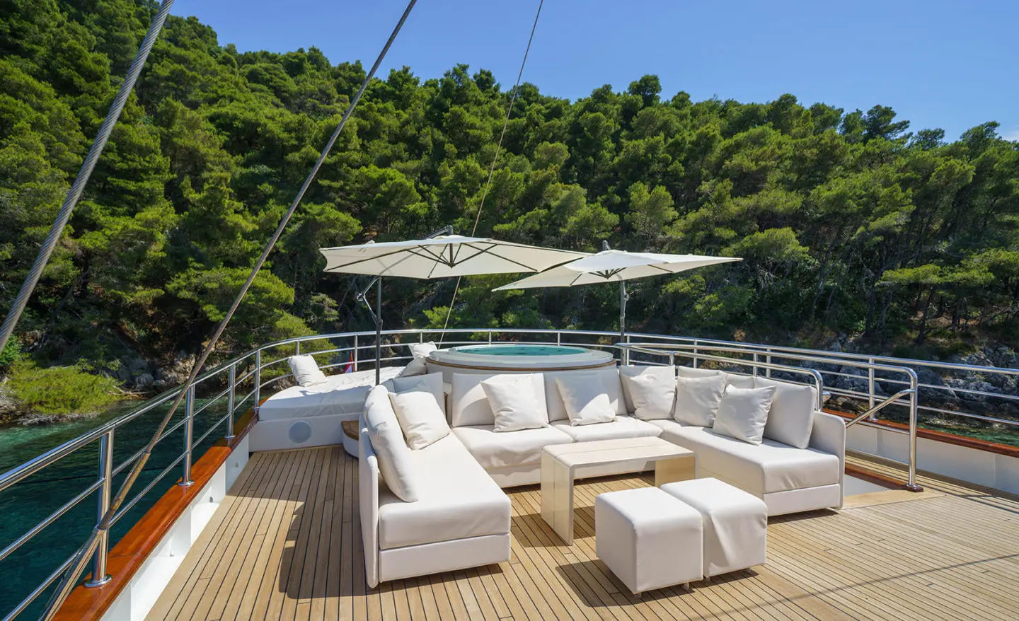 Maia motor yacht lounge area with white cushioned seating and large umbrella