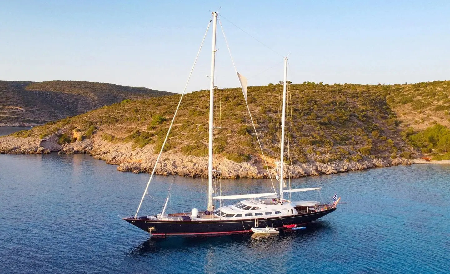 Tamarita yacht anchored in clear blue water with two masts and deck area visible