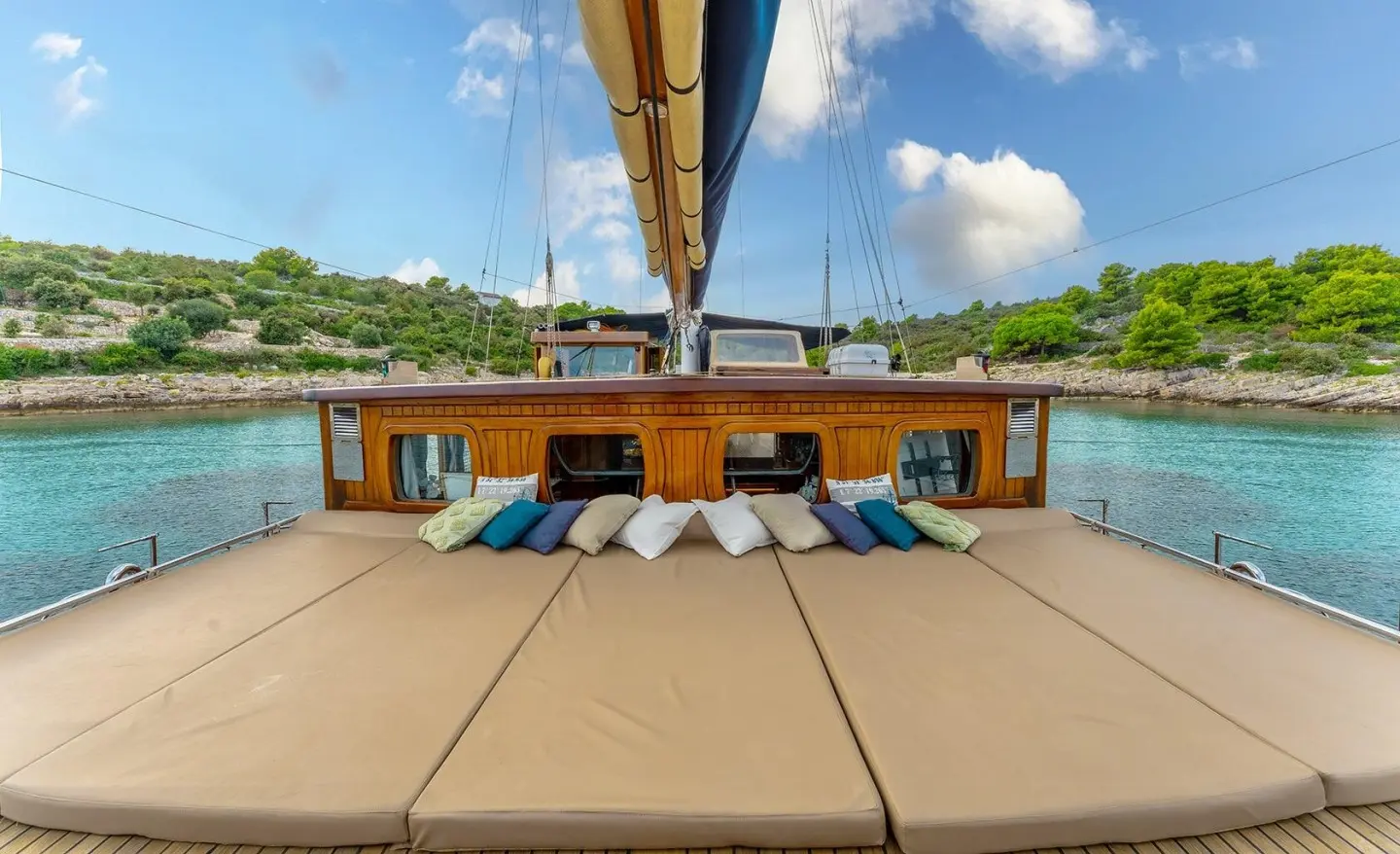 Smart Spirit yacht deck with seating area and a sunlit seaside background