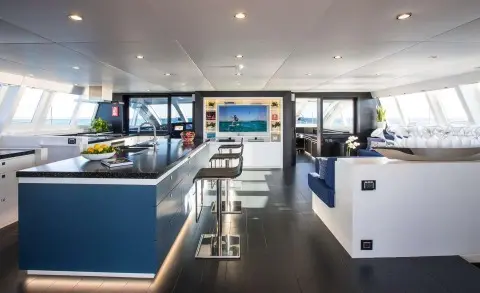 Interior view of Cartouche luxury yacht saloon with seating, table, and windows