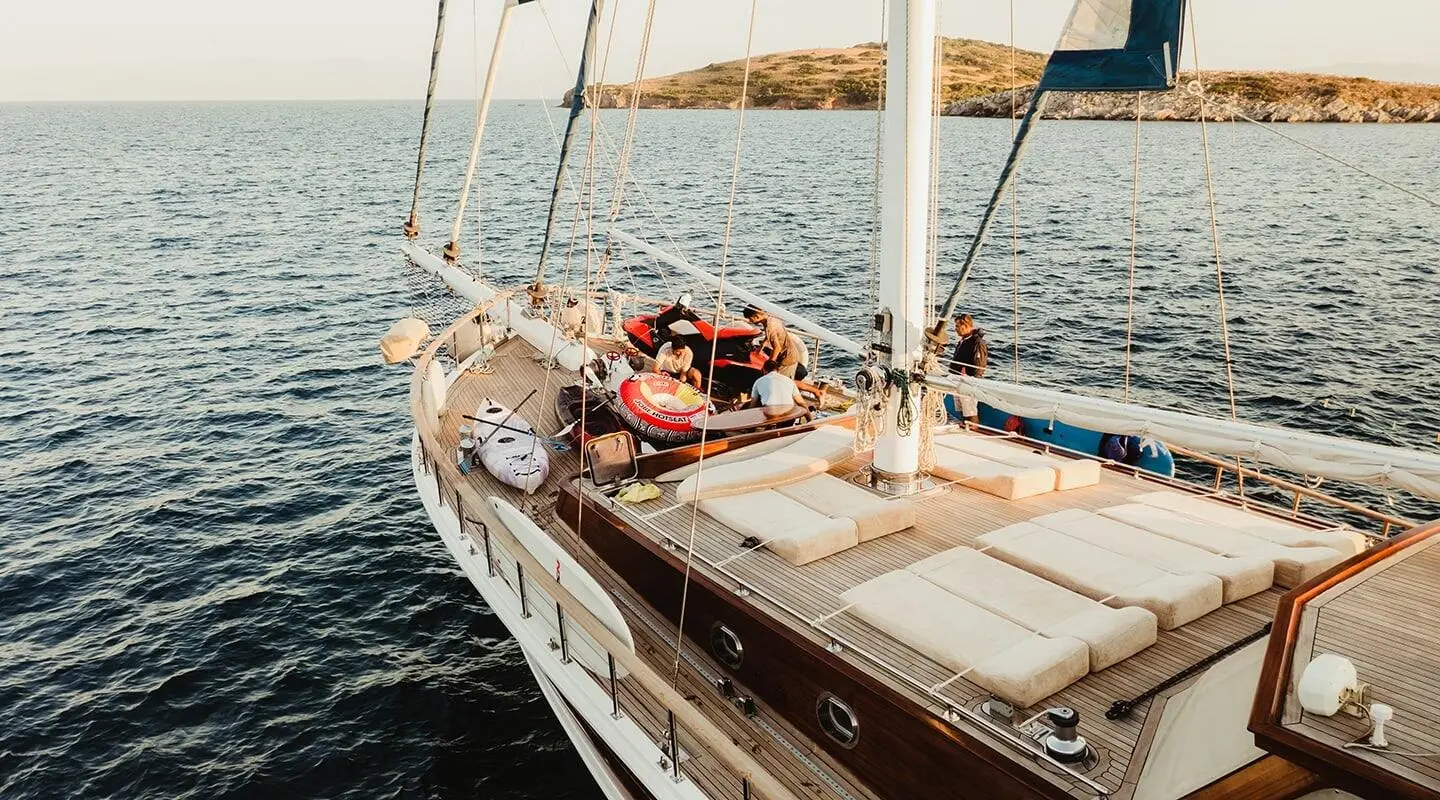 Sunlit yacht deck with seating cushions and railing on the water